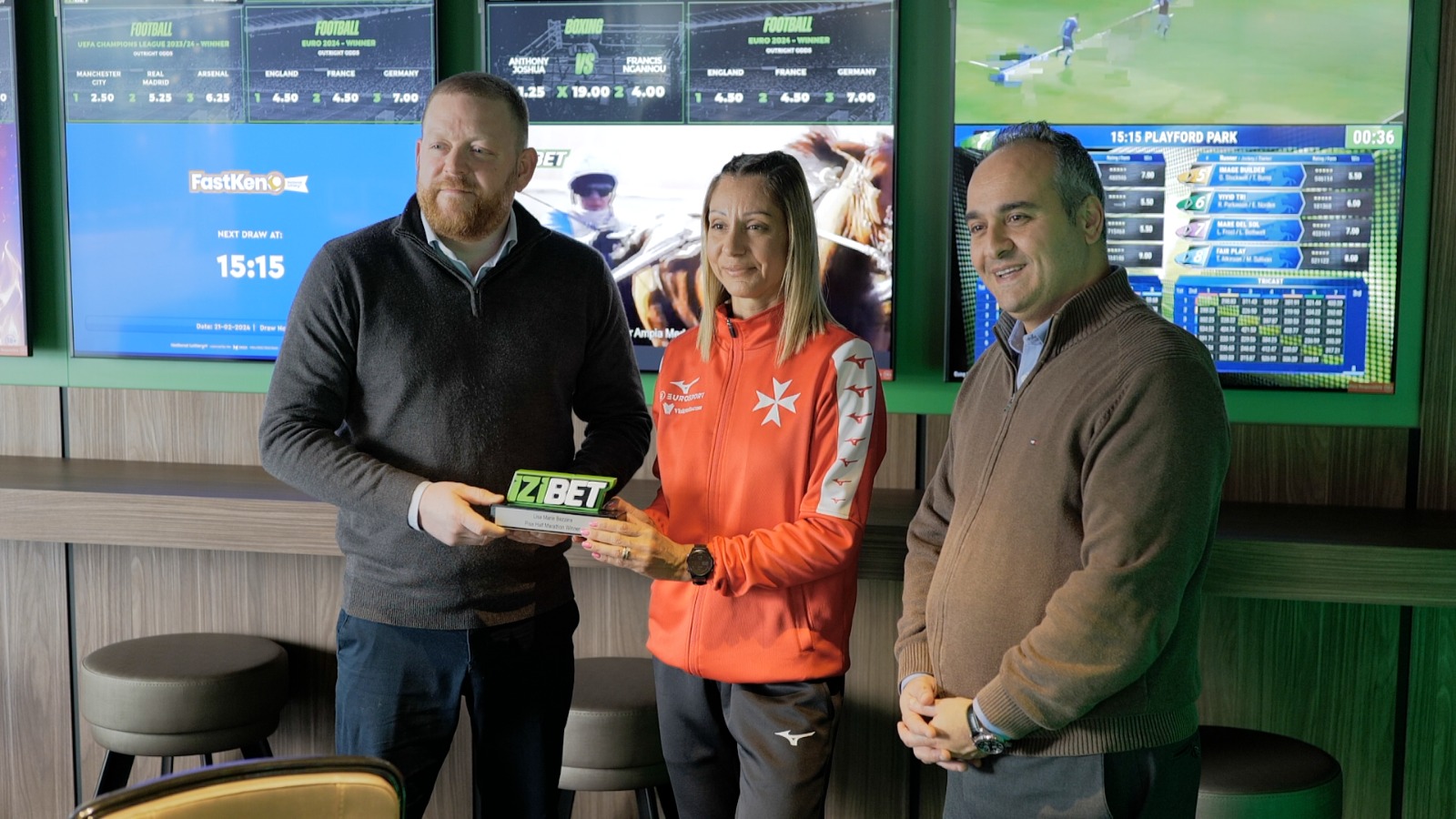 James Morgan, Brand Manager at IZI Group plc presenting the IZIBET Elite Athlete Award for November-December 2023 to Lisa Marie Bezzina together with Sandro Micallef, President of the Malta Sports Journalists Association.